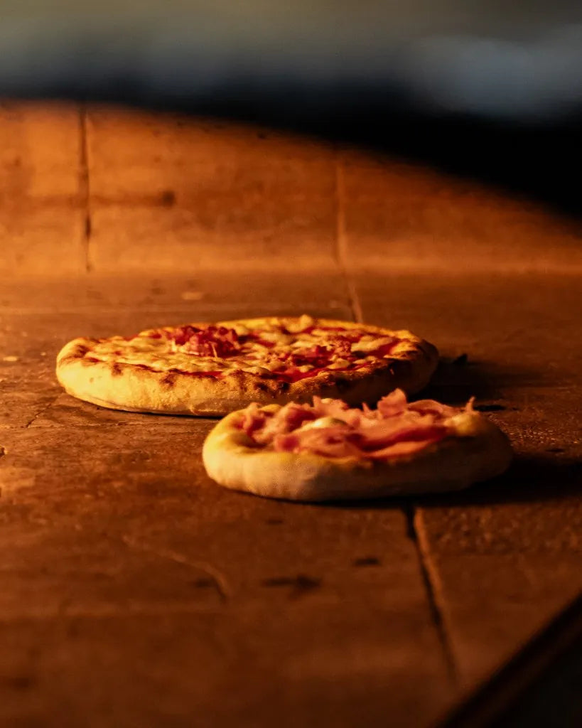 Twee pizza's in een houtoven